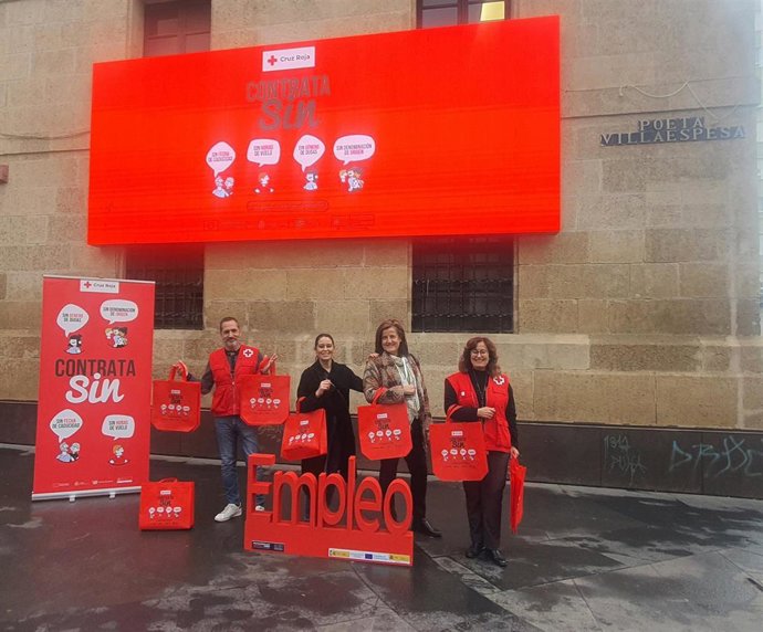 Miembros del Plan de Empleo de Cruz Roja Almería muestran material de la campaña 'Contrata Sin'.