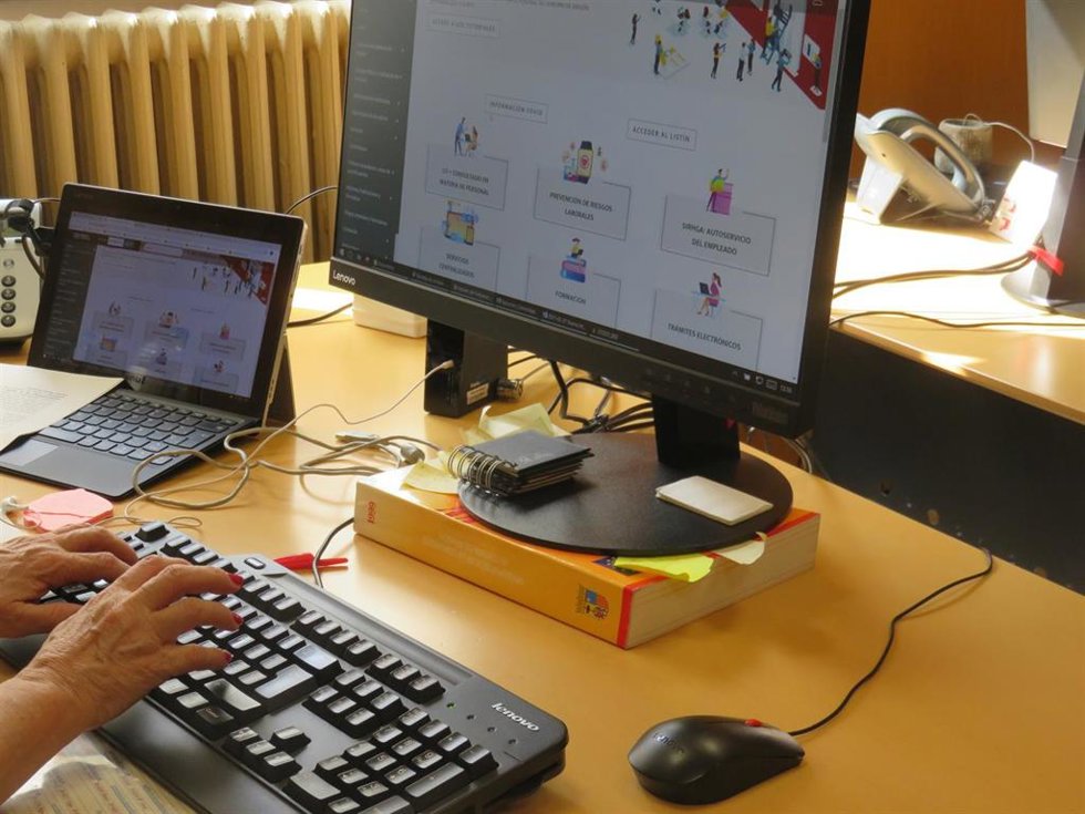 Unas manos de mujer se colocan en el teclado de un ordenador.