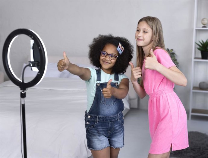 Meninas gravando vídeos.