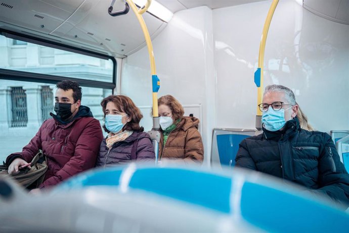 Archivo - Varias personas con mascarilla en un autobús.