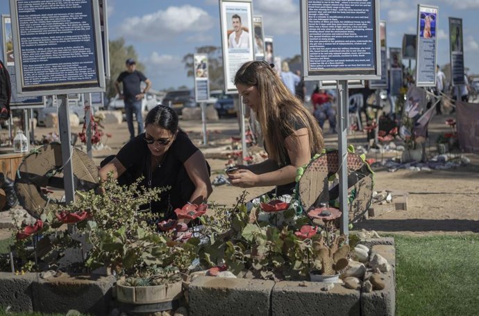 Archivo - 07 October 2025, Israel, Re'im: Two women lay flowers at the Nova festival site in Re'im during a ceremony to commemorate the 2 year anniversary of the 7th of October Hamas led attack. Photo: Ilia Yefimovich/dpa