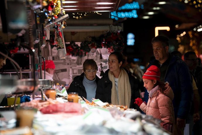 Archivo - Varias personas miran el género expuesto, en el Mercado de la Boquería, a 14 de diciembre de 2023, en Barcelona, Catalunya (España). 