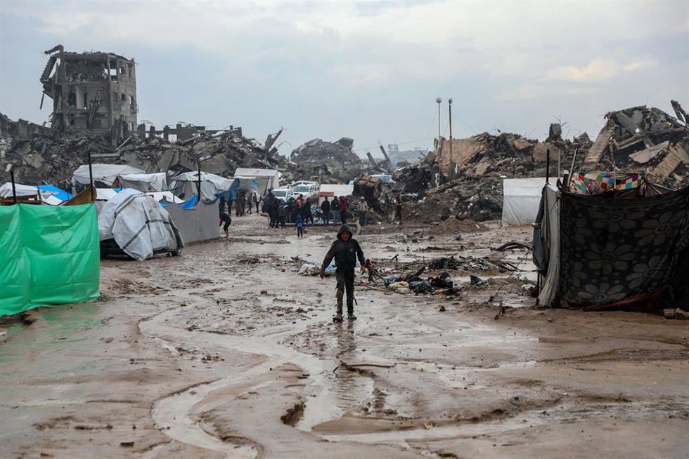 Un niño palestino permanece afuera durante la lluvia en el barrio de Zeitún, en el sureste de la ciudad de Gaza