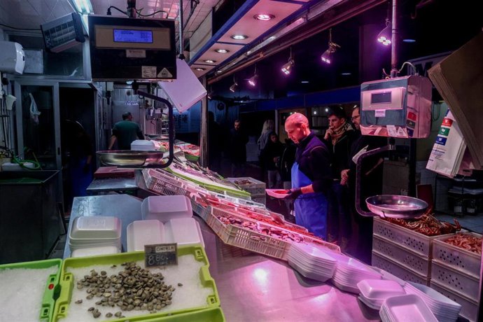 Archivo - Varias personas realizan sus últimas compras antes de la cena de Nochebuena en un mercado, a 24 de diciembre de 2023, en Madrid (España). 