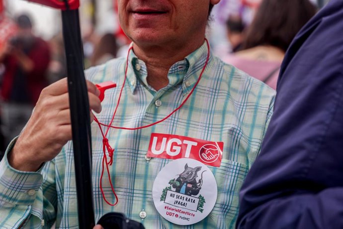 Archivo - Empleado del sector financiero con pegatinas de la UGT se concentra para pedir una compensación salarial.