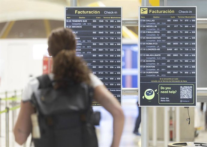 Archivo - Una persona observa las pantallas informativas, en el Aeropuerto Adolfo Suárez Madrid-Barajas