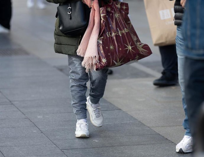 Archivo - Una persona lleva una bolsa con regalos para Reyes, a 5 de enero de 2024, en Madrid (España). 