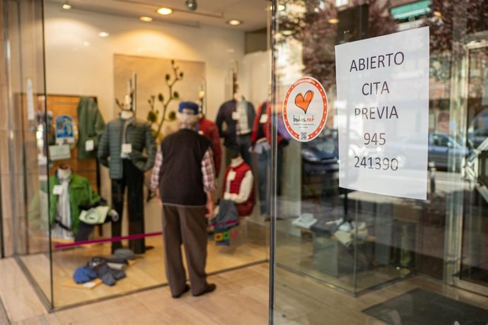 Archivo - Un hombre observa el escaparate de un establecimiento