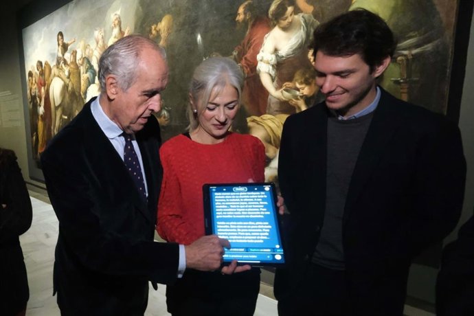 La consejera de Cultura muestra la App para seguir la exposición con obras de la Caridad junto a sus creadores.