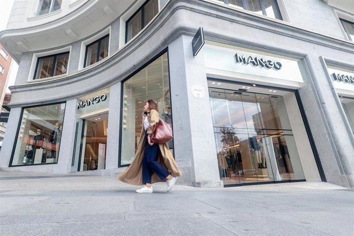 Archivo - Una persona pasa delante de la nueva tienda de Mango, en Plaza de España