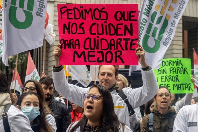 Manifestante com uma faixa com o slogan "Pedimos que cuidem de nós para cuidarmos melhor de você" durante a manifestação "Todos unidos por um objetivo comum: nosso próprio estatuto", em 15 de novembro de 2025, em Madri (Espanha). A manifestação, organizad