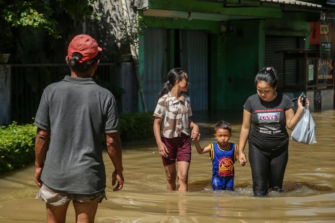 December 5, 2025, Bandung Regency, West Java, Indonesia: Residents walk through floodwaters in Dayeuhkolot, Bandung Regency, West Java, on December 5, 2025. The Bandung Regency Regional Disaster Management Agency (BPBD) stated that at least 34,000 people 