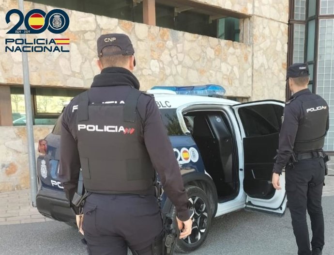 Agentes de la Policía Nacional, junto a un vehículo policial. Recurso.