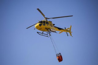 Archivo - El piloto de helicópteros Juan Cruz Nicolás Pastor vuela un helicóptero sosteniendo una Bambi Bucket, una bolsa con una capacidad de entre 800 - 1.000 litros en el Parque de Bomberos de Las Rozas, a 17 de agosto de 2021, en Madrid, (España). 