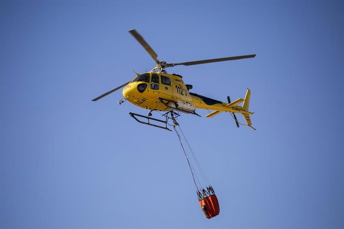 Archivo - El piloto de helicópteros Juan Cruz Nicolás Pastor vuela un helicóptero sosteniendo una Bambi Bucket, una bolsa con una capacidad de entre 800 - 1.000 litros en el Parque de Bomberos de Las Rozas, a 17 de agosto de 2021, en Madrid, (España). 