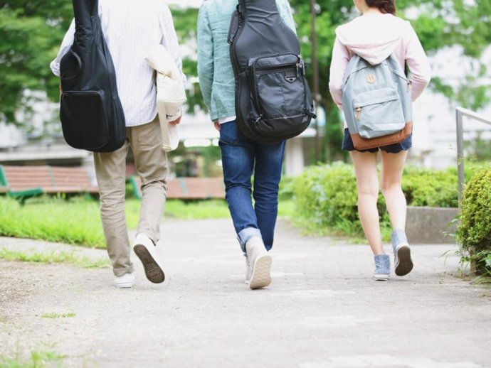 Tres jóvenes caminando de espaldas.