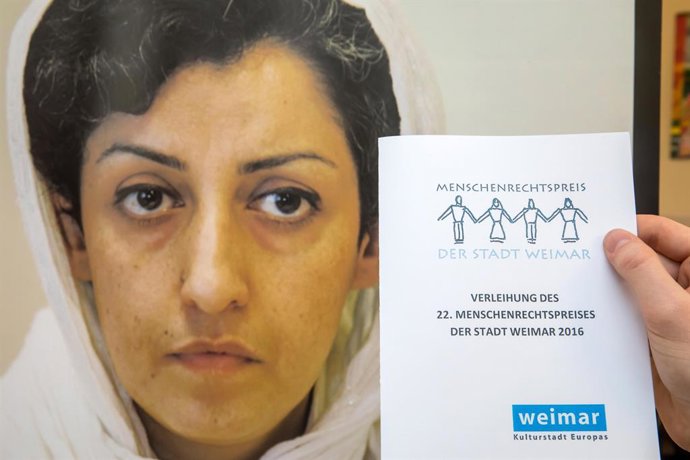Archivo - FILED - 10 December 2016, Thuringia, Weimar: A man holds the invitation to the event at a press conference during the award ceremony of the Weimar Human Rights Prize to Iranian activist Narges Mohammadi. Photo: -/dpa-Zentralbild/dpa