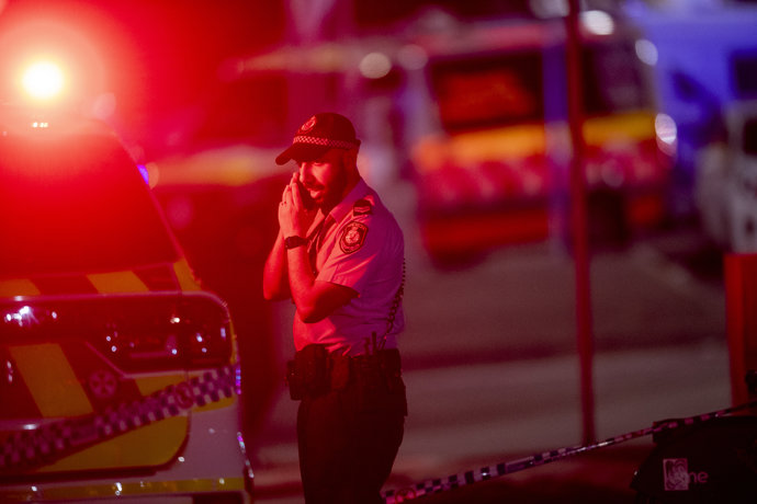 Un agente de la Policía australiana habla por teléfono tras el tiroteo masivo en la playa de Bondi, en Sídney. Se cree que varias personas han muerto después de que hombres armados abrieran fuego contra una multitud reunida en la playa de Bondi.