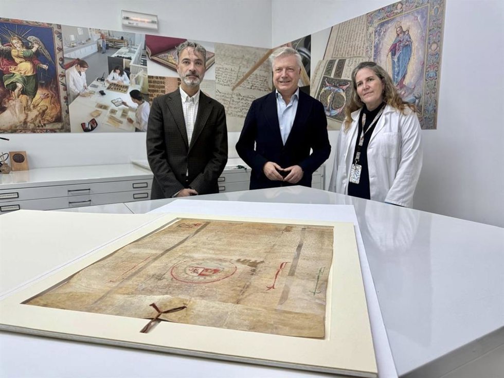 Ignacio Montoro y Primo Jurado, junto a una técnica del IAPH, ante el restaurado 'Privilegio rodado de confirmación de Alfonso XI a favor de Baeza'.