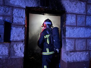 Archivo - Un bombero en la extinción del incendio de una vivienda en un municipio de Madrid
