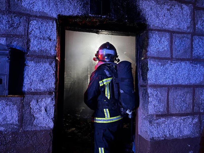 Archivo - Un bombero en la extinción del incendio de una vivienda en un municipio de Madrid
