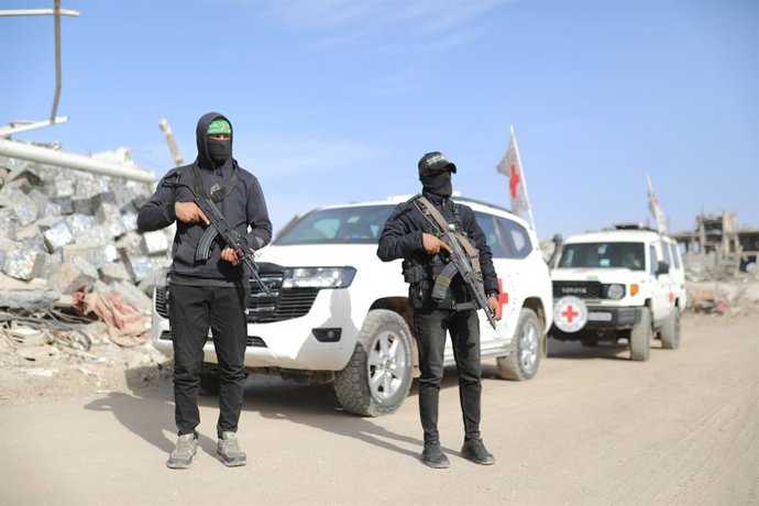 8 de dezembro de 2025, Cidade de Gaza, Faixa de Gaza, Território Palestino: Equipes afiliadas à ala militar do Hamas, as Brigadas Al-Qassam, e funcionários do Comitê Internacional da Cruz Vermelha (CICV), juntamente com maquinário pesado pertencente ao Eg