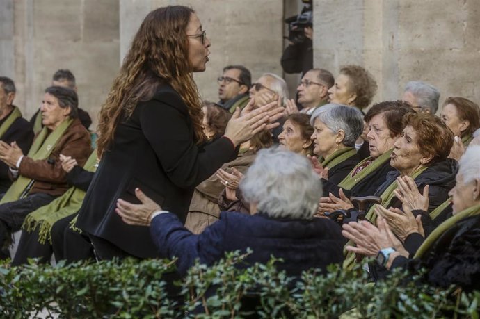 Archivo - Una mujer dirige al coro ‘Les Veus de la Memòria’ en un concierto navideño en el Palau del Temple, a 19 de diciembre de 2022