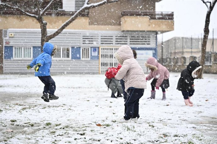 Archivo - Varios niños juegan en la calle bajo la nieve, en Zaragoza, Aragón (España). 