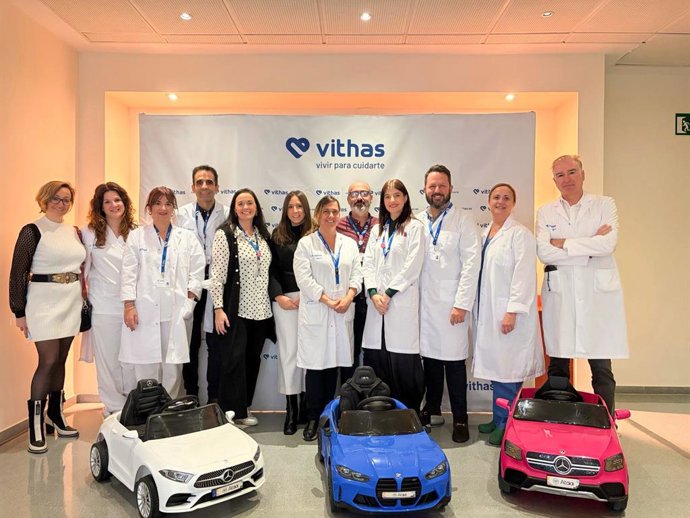 Representantes del Hospital Vithas Almería y de la empresa ATAA Cars posan junto a los tres cochecitos eléctricos donados.