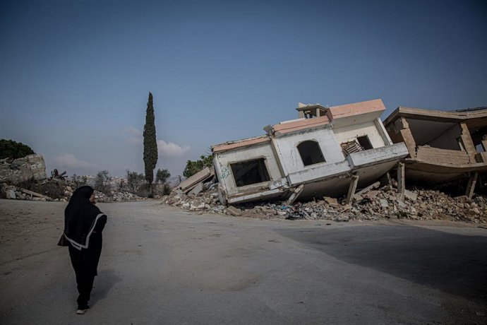 Archivo - Una mujer camina cerca de un edificio derrumbado en la ciudad de Aita al Chaab, en Líbano, a causa de los ataques del Ejército de Israel (archivo)