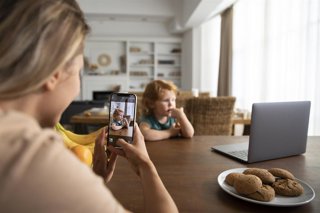 Madre haciendo una foto a su hijo con el móvil