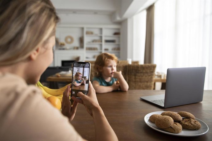 Madre haciendo una foto a su hijo con el móvil