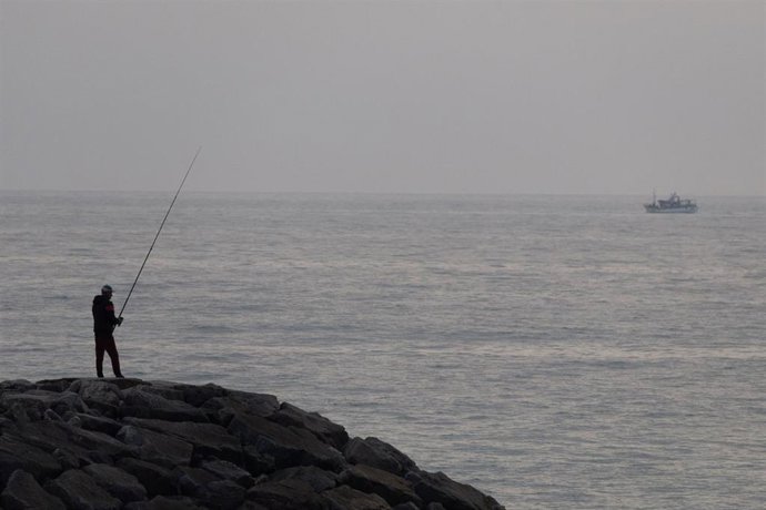 Archivo - Un hombre pesca frente a las costas de Portugal