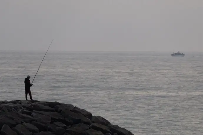 Un hombre pesca frente a las costas de Portugal