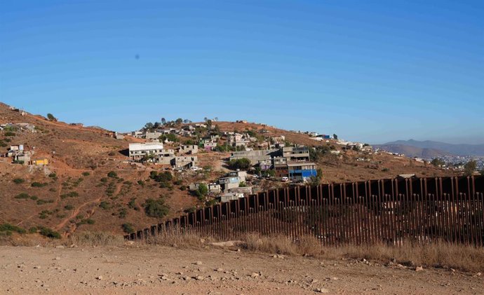 Archivo - El muro fronterizo entre Estados Unidos y México, visto desde las afueras de San Diego, en California, con Tijuana al fondo.