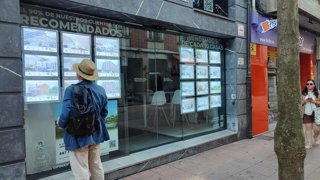 Archivo - Un hombre mira anuncios de una agencia inmobiliaria en Oviedo, con viviendas de segunda mano a la venta. Compraventa de viviendas, alquiler.