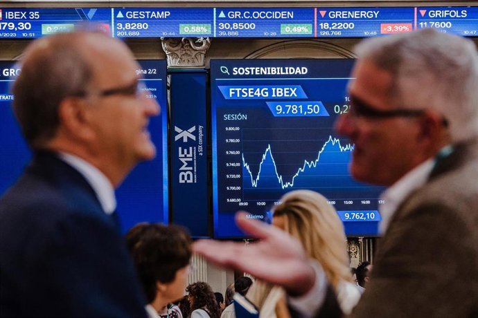 Archivo - (Foto de ARCHIVO) Varias personas frente a los paneles del Ibex 35 en el Palacio de la Bolsa