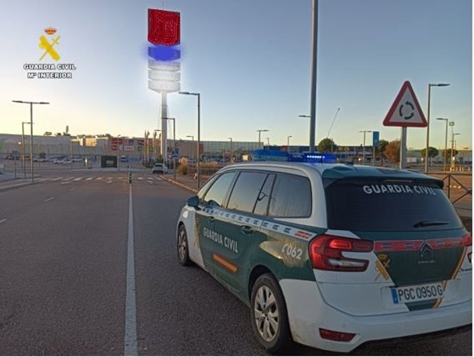 Coche de la Guardia Civil en el aparcamiento del centro comercial.