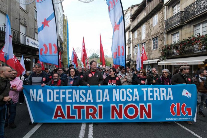 Manifestantes portan una pancarta con lema 'En defensa de nuestra tierra. Altri no' durante una manifestación contra el proyecto de Altri.