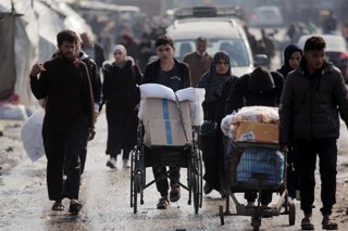 Varias personas se desplazan cargadas de enseres tras las fuertes lluvias que han azotado la Franja de Gaza