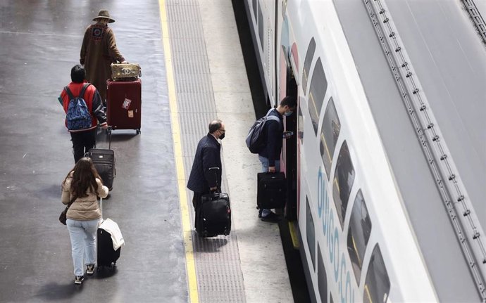 Archivo - Varias personas, con maletas, en el andén antes de coger un tren de alta velocidad