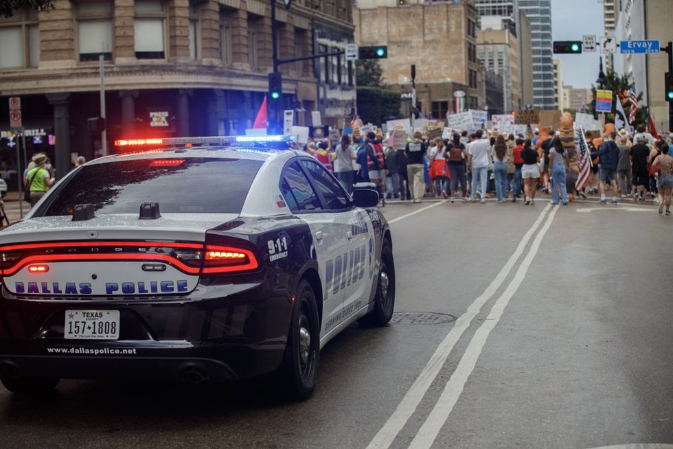 October 18, 2025, Dallas, Texas, USA: A Dallas Police Department vehicle escorts protesters down Elm Street  in downtown Dallas Texas,as they march during the No Kings protest n downtown Dallas Texas on Saturday.