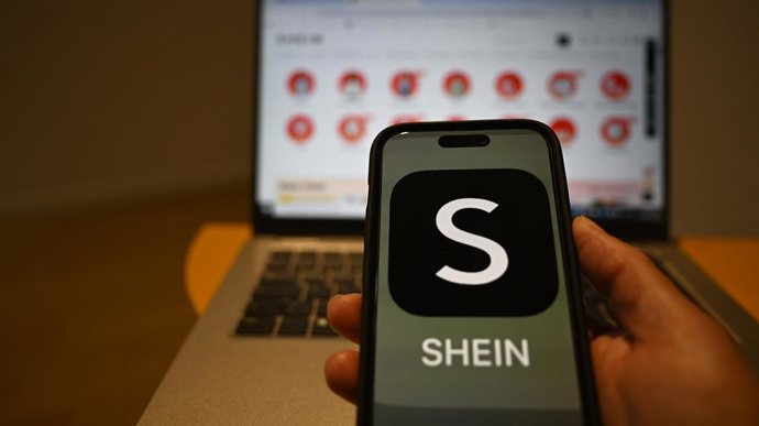 Archivo - FILED - 29 de abril de 2024, Berlim: O logotipo da Shein é visto em um smartphone, enquanto o site do varejista on-line chinês está aberto em um laptop atrás dele. Foto: Monika Skolimowska/dpa