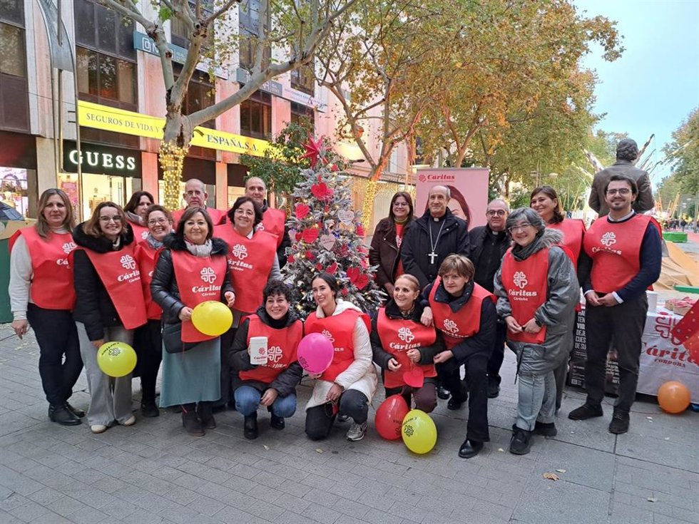 Jesús Fernández (detrás, 4 dcha.), posa, junto a responsables, voluntarios y técnicos de Cáritas, junto al 'Árbol de Navidad Solidario'.
