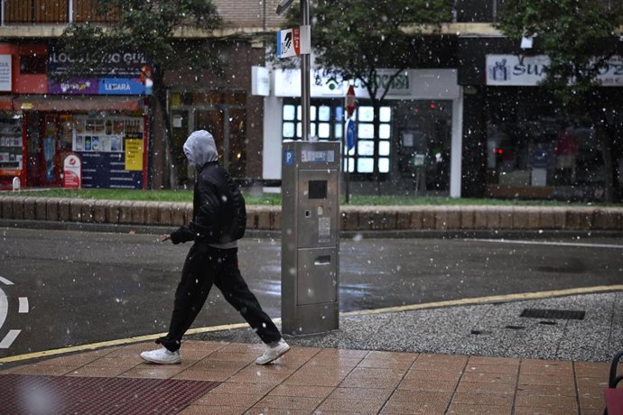 Archivo - Una persona camina por la calle bajo la nieve, a 19 de enero de 2024, en Zaragoza, Aragón (España).