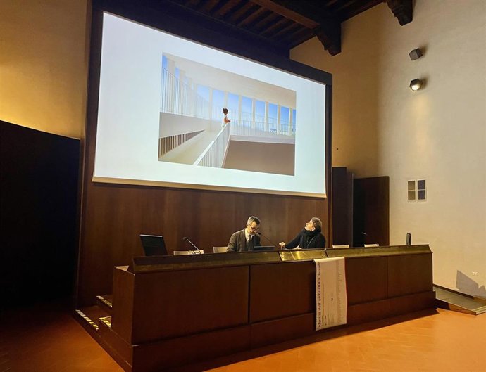 Pablo Millán (i) interviene en el congreso bajo una imagen del edificio de acceso a la cisterna romana de La Calderona.