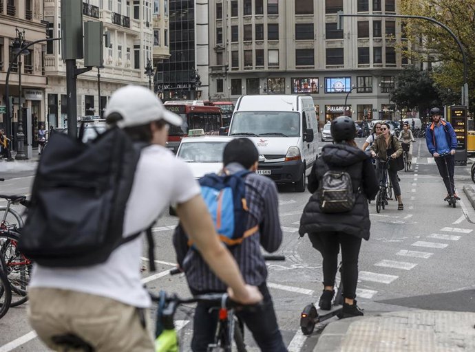 Archivo - Varias personas pasan por un carril bici del centro de Valencia, en imagen de archivo.