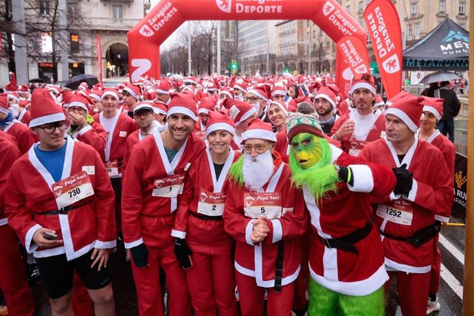 El concejal de Deportes, Félix Brocate junto a los atletas hermanos Sergio y Ana Turull en la salida de la segunda carrera solidaria Papá Noel Zaragoza que ha reunido a 4.000 participantes entre elfos y papás noel.