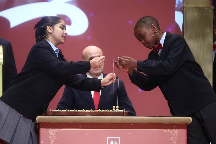 Dos niños del Colegio de San Ildefonso, cantan los números premiados durante la celebración del Sorteo Extraordinario de la Lotería de Navidad 2025, en el Teatro Real, a 22 de diciembre de 2025, en Madrid (España). El Sorteo Extraordinario de la Lotería d