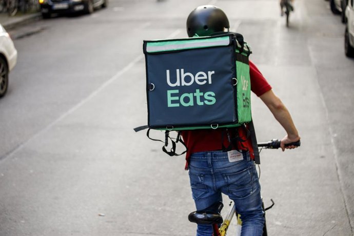 Archivo - FILED - 02 September 2021, Berlin: Silvan, a driver for food delivery service Uber Eats, rides a bicycle with a transport box on his back on a street in the Friedrichshain district of Berlin. Photo: Carsten Koall/dpa